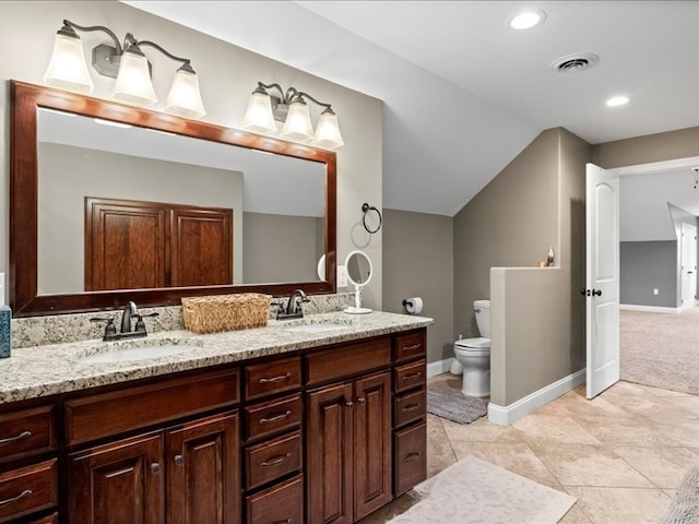 bathroom with toilet, lofted ceiling, vanity, and tile patterned flooring