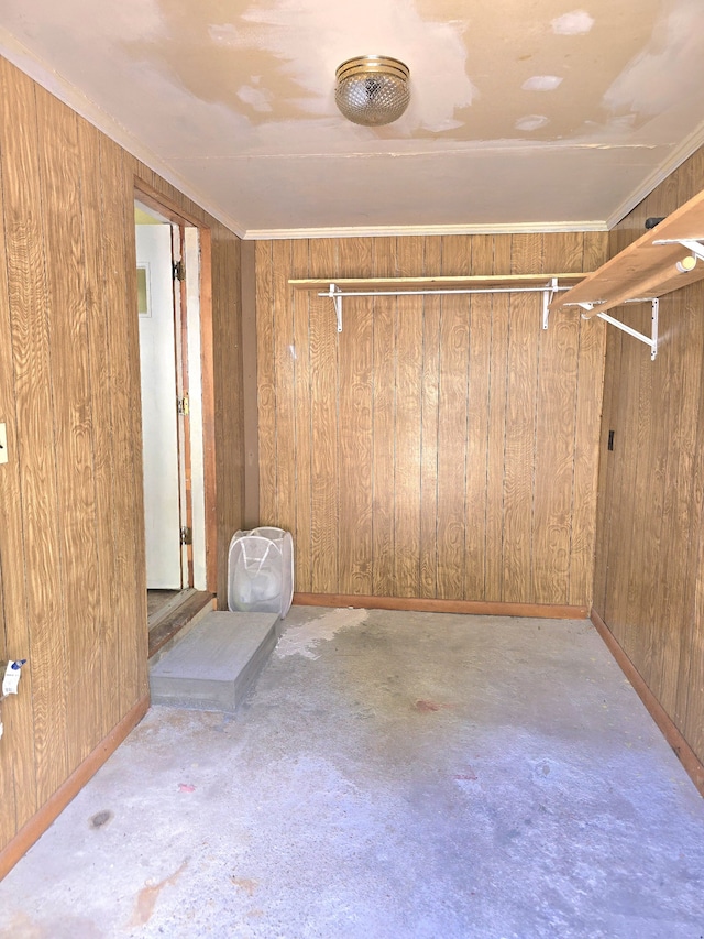 unfurnished room with crown molding and wooden walls