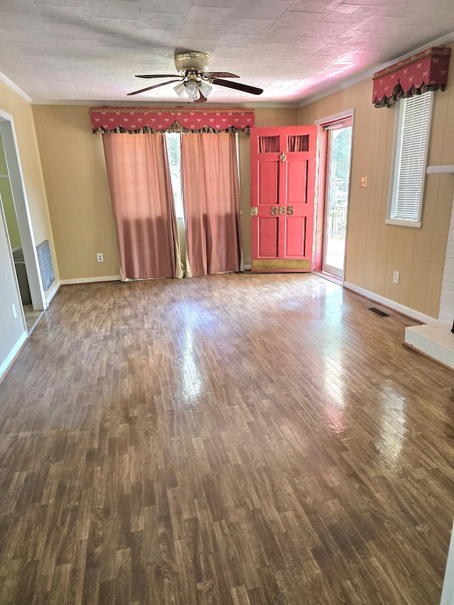 interior space with ornamental molding, dark hardwood / wood-style floors, a wealth of natural light, and ceiling fan