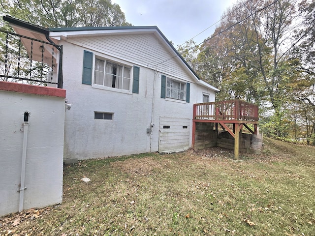 back of house featuring a lawn and a deck