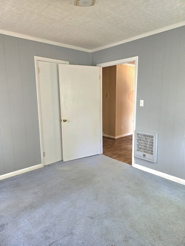 spare room featuring ornamental molding, a textured ceiling, and carpet flooring