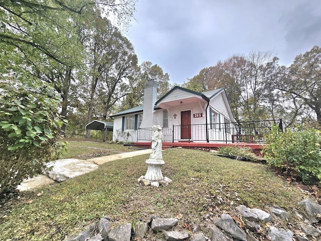 view of front of home featuring a front lawn, a carport, and covered porch