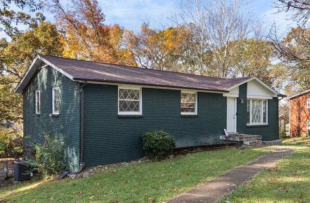 view of front of house with central air condition unit and a front yard