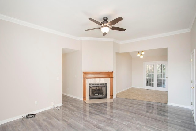 unfurnished living room with hardwood / wood-style floors, ceiling fan with notable chandelier, crown molding, and french doors