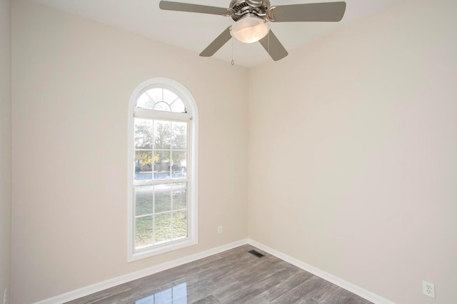 spare room with ceiling fan, a healthy amount of sunlight, and wood-type flooring