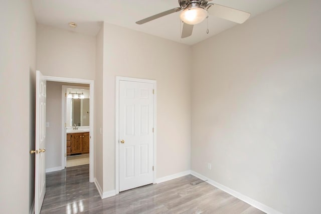 unfurnished room with ceiling fan, wood-type flooring, and sink