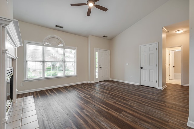 unfurnished living room featuring dark wood-type flooring, ceiling fan, and high vaulted ceiling