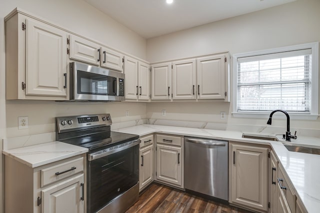 kitchen featuring stainless steel appliances, sink, dark hardwood / wood-style floors, light stone countertops, and white cabinetry