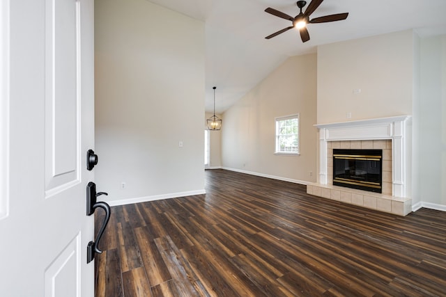 unfurnished living room featuring a tiled fireplace, high vaulted ceiling, dark hardwood / wood-style flooring, and ceiling fan