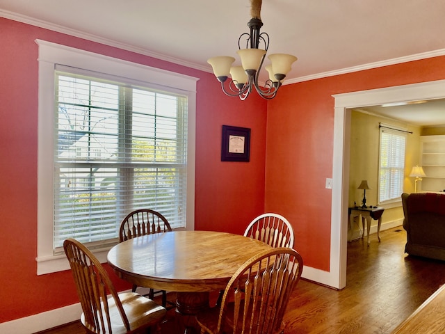 dining area featuring a chandelier, wood-type flooring, and ornamental molding