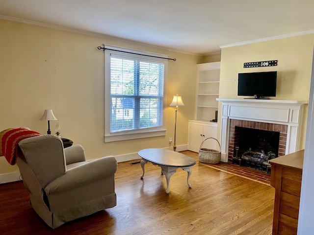 living area featuring a fireplace, hardwood / wood-style flooring, and crown molding