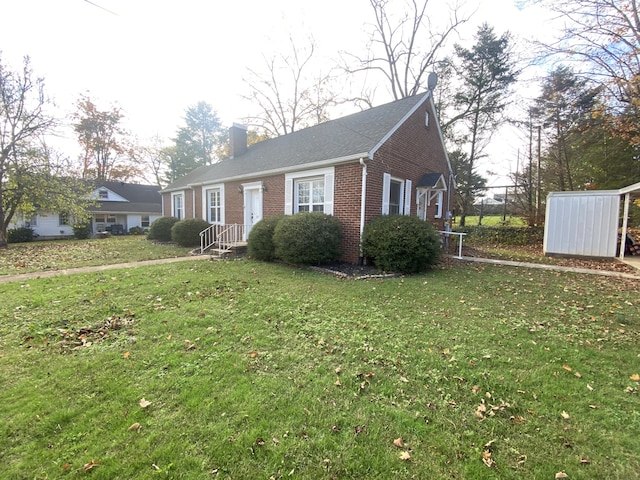 view of front of property featuring a front lawn and a shed