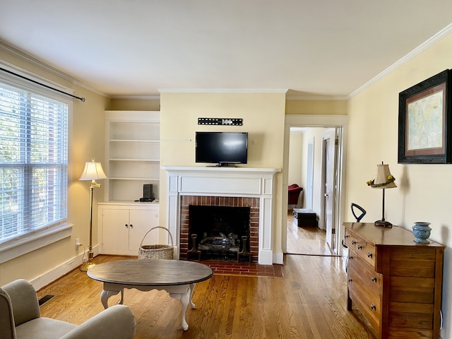 living room with a brick fireplace, hardwood / wood-style flooring, and crown molding