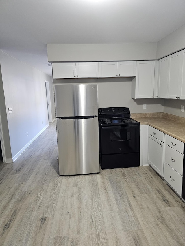 kitchen featuring black electric range, light hardwood / wood-style floors, white cabinetry, and stainless steel fridge