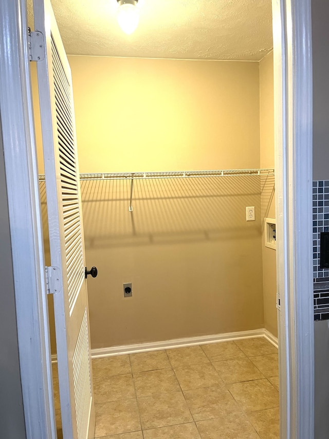 laundry room featuring washer hookup, light tile patterned floors, a textured ceiling, and electric dryer hookup