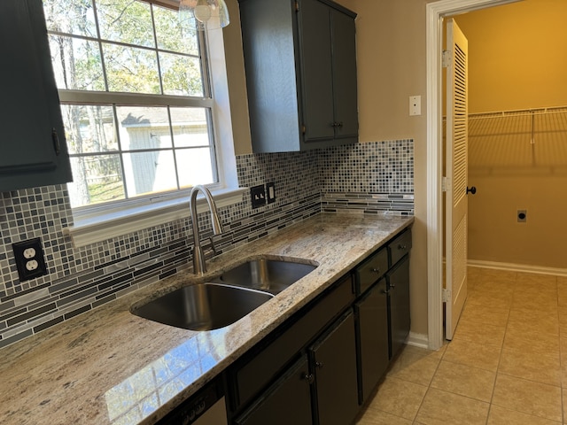 kitchen featuring tasteful backsplash, sink, light tile patterned floors, and light stone counters