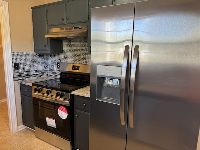 kitchen with light tile patterned flooring, appliances with stainless steel finishes, backsplash, exhaust hood, and light stone countertops