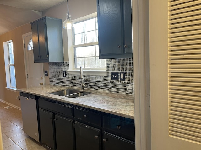 kitchen featuring sink, hanging light fixtures, stainless steel dishwasher, light tile patterned floors, and light stone countertops