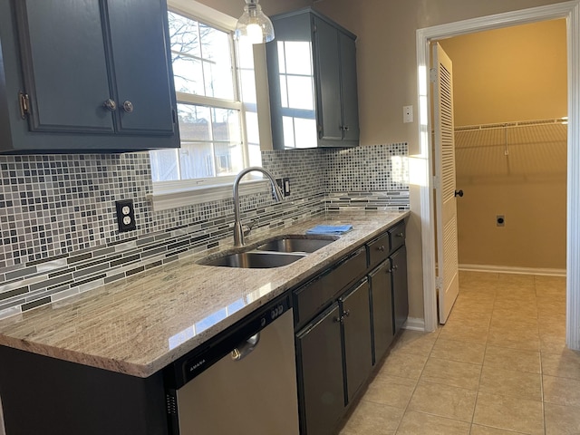 kitchen with sink, light tile patterned floors, dishwasher, light stone counters, and decorative light fixtures