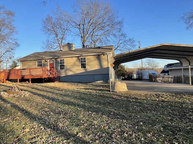 view of front facade with a wooden deck, a carport, and a front lawn