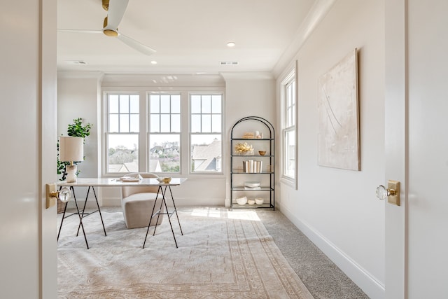 office with ceiling fan, light colored carpet, visible vents, baseboards, and ornamental molding