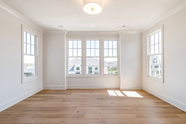 empty room featuring ornamental molding and a healthy amount of sunlight