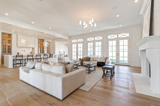 living area with ornamental molding, french doors, light wood-type flooring, a notable chandelier, and recessed lighting