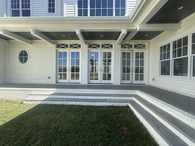 exterior space with a patio area, a lawn, and french doors