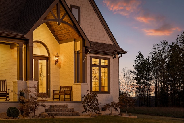 property exterior at dusk featuring a yard