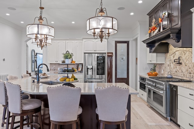 kitchen with stainless steel appliances, white cabinetry, and a kitchen island with sink