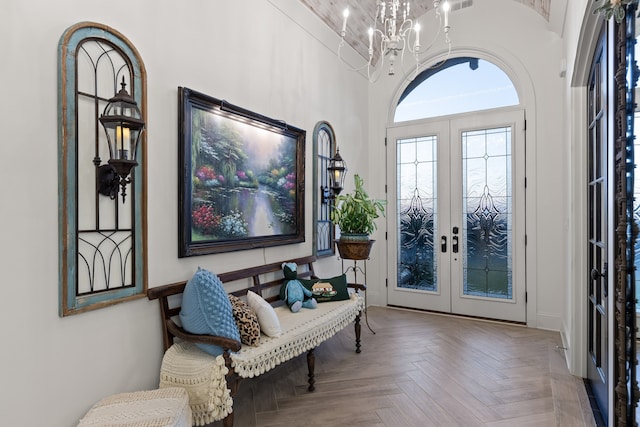 entryway featuring parquet flooring, an inviting chandelier, and french doors