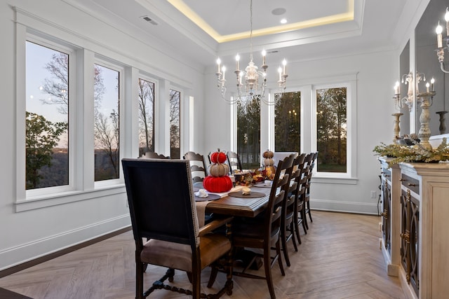 dining room featuring parquet floors, a tray ceiling, and an inviting chandelier