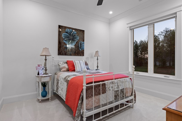 carpeted bedroom featuring ceiling fan and ornamental molding