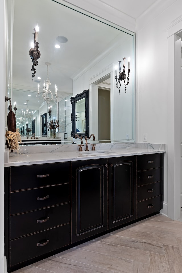 bathroom with wood-type flooring, vanity, and ornamental molding