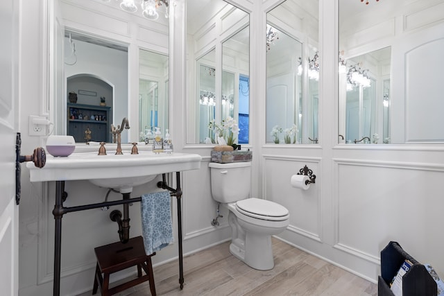 bathroom with hardwood / wood-style flooring, a healthy amount of sunlight, and toilet