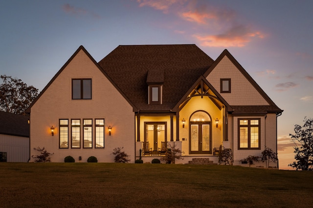 view of front of property with a yard and french doors