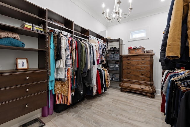 walk in closet featuring an inviting chandelier and light hardwood / wood-style floors