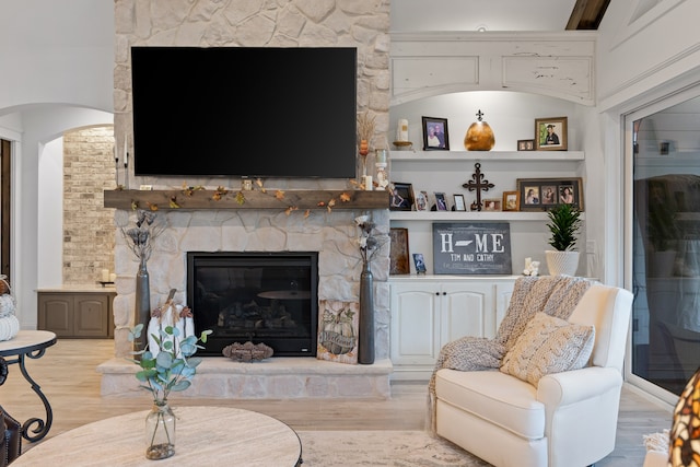 living room featuring light wood-type flooring and a fireplace