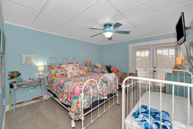 carpeted bedroom with ceiling fan and a drop ceiling