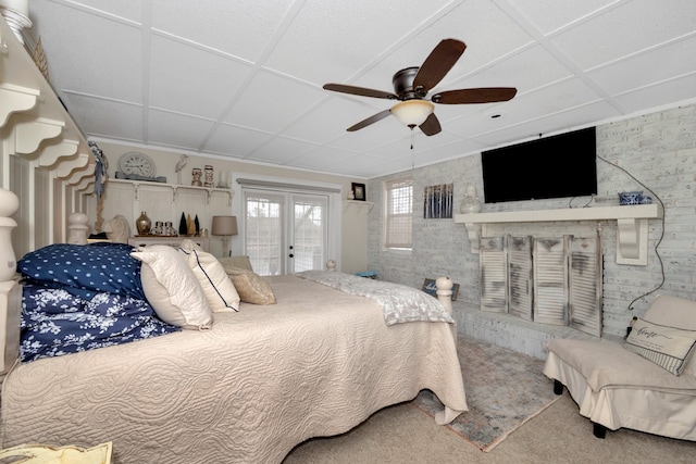 bedroom with french doors, access to exterior, carpet floors, ceiling fan, and brick wall