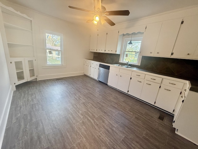 kitchen with stainless steel dishwasher, a healthy amount of sunlight, tasteful backsplash, and dark hardwood / wood-style floors