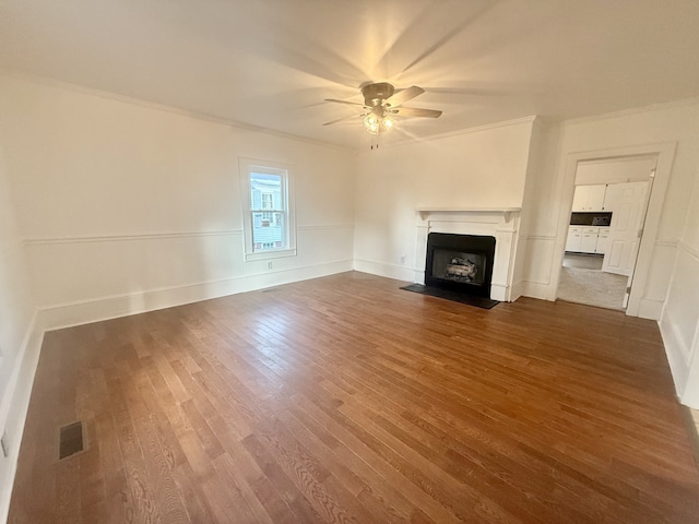 unfurnished living room featuring dark hardwood / wood-style floors, crown molding, and ceiling fan