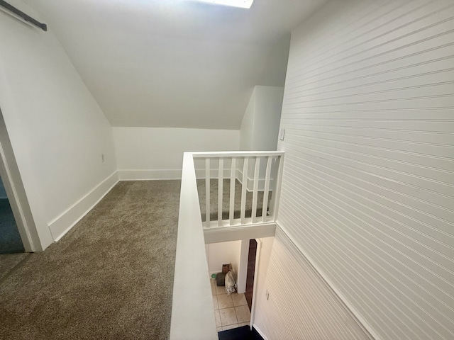 staircase featuring lofted ceiling and carpet