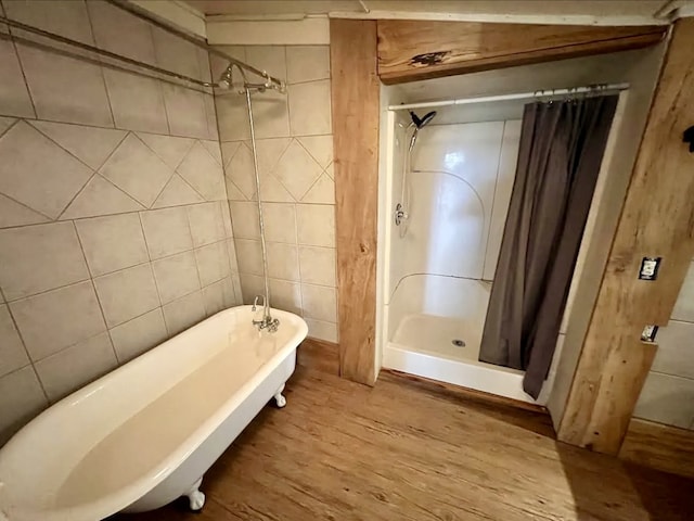 bathroom with tile walls, plus walk in shower, and wood-type flooring