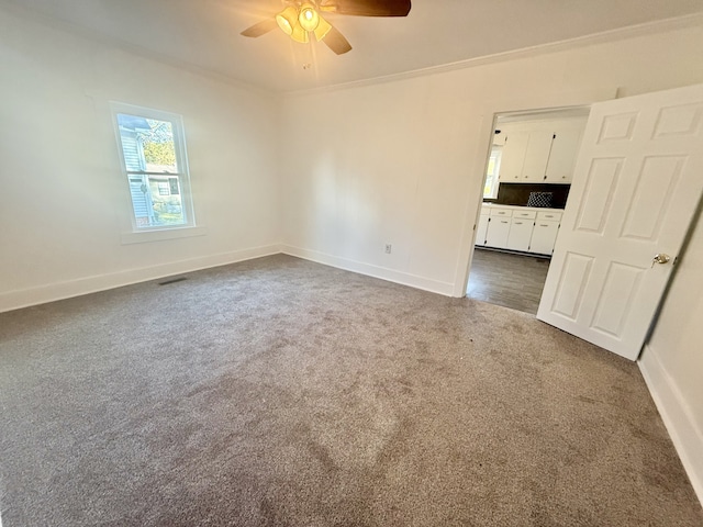 carpeted empty room featuring ceiling fan and ornamental molding