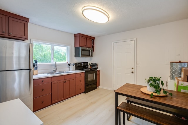 kitchen featuring light hardwood / wood-style flooring, a textured ceiling, sink, and stainless steel appliances