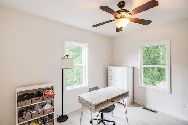 home office with ceiling fan, a healthy amount of sunlight, and light hardwood / wood-style flooring