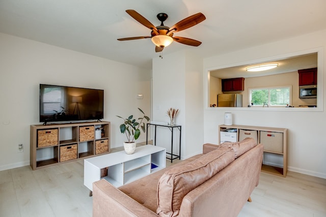 living room with light hardwood / wood-style floors and ceiling fan