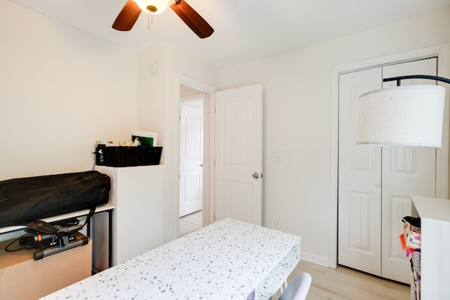 bedroom with light hardwood / wood-style flooring, ceiling fan, and a closet