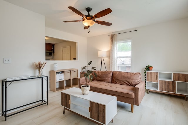 living room with light wood-type flooring and ceiling fan